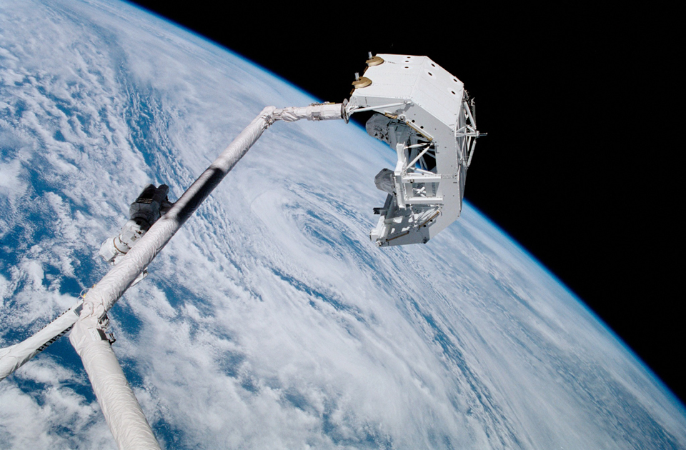 The Canadarm, performing the first robot-to-robot transfer in space, April 2001. Photo: NASA